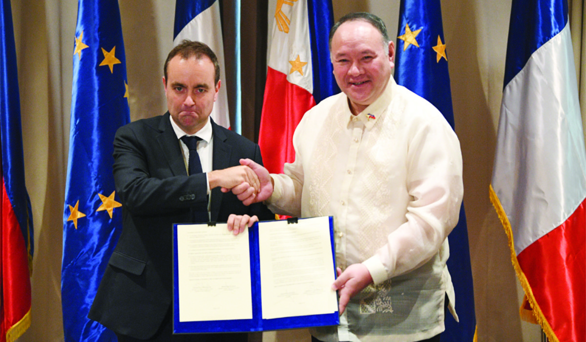 French Minister for the Armed Forces Sebastien Lecornu, left, with his Philippine counterpart Secretary Gilberto Teodoro as they hold a document during a joint press conference in Manila on Saturday. (AP)