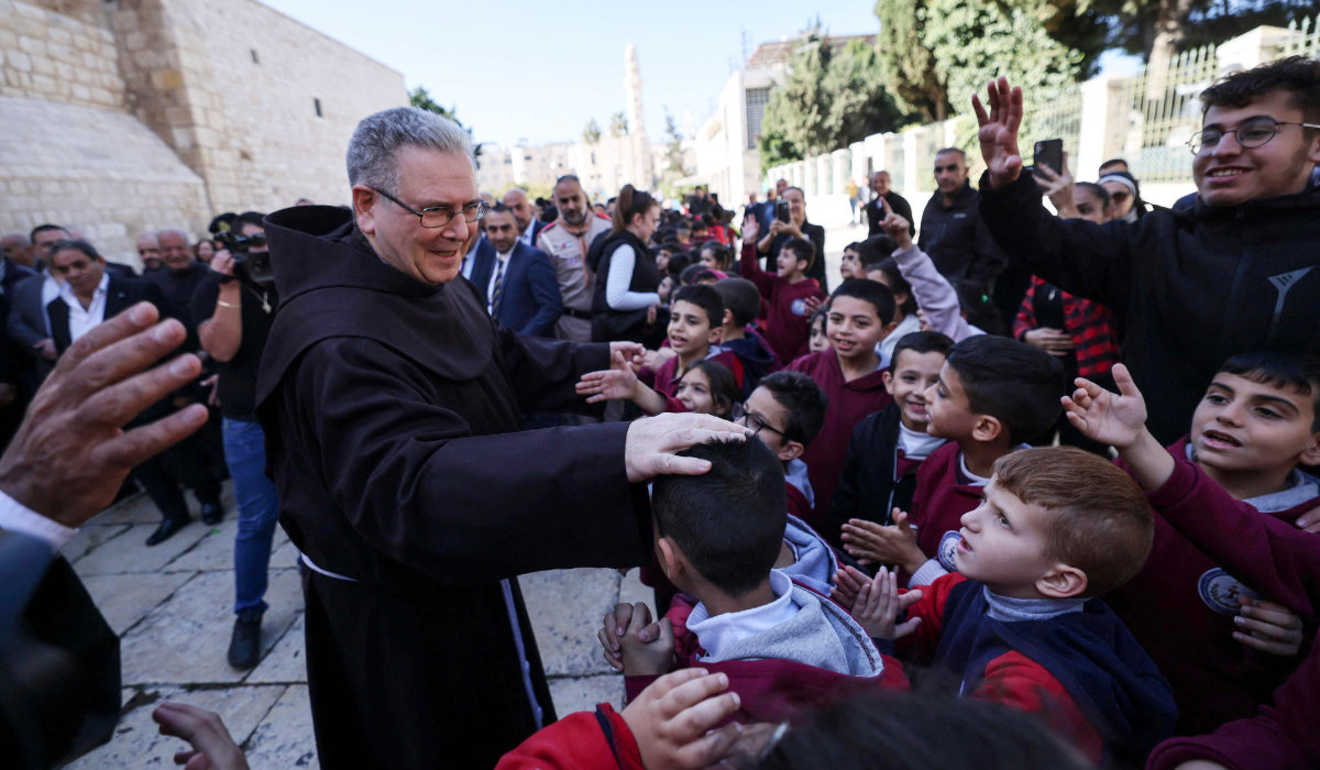 Custodian of the Holy Land Father Francesco Patton blesses children outside the Church of the Nativity upon his arrival on Saturday to launch the Christmas season, in the occupied West Bank city of Bethlehem. (AFP)
