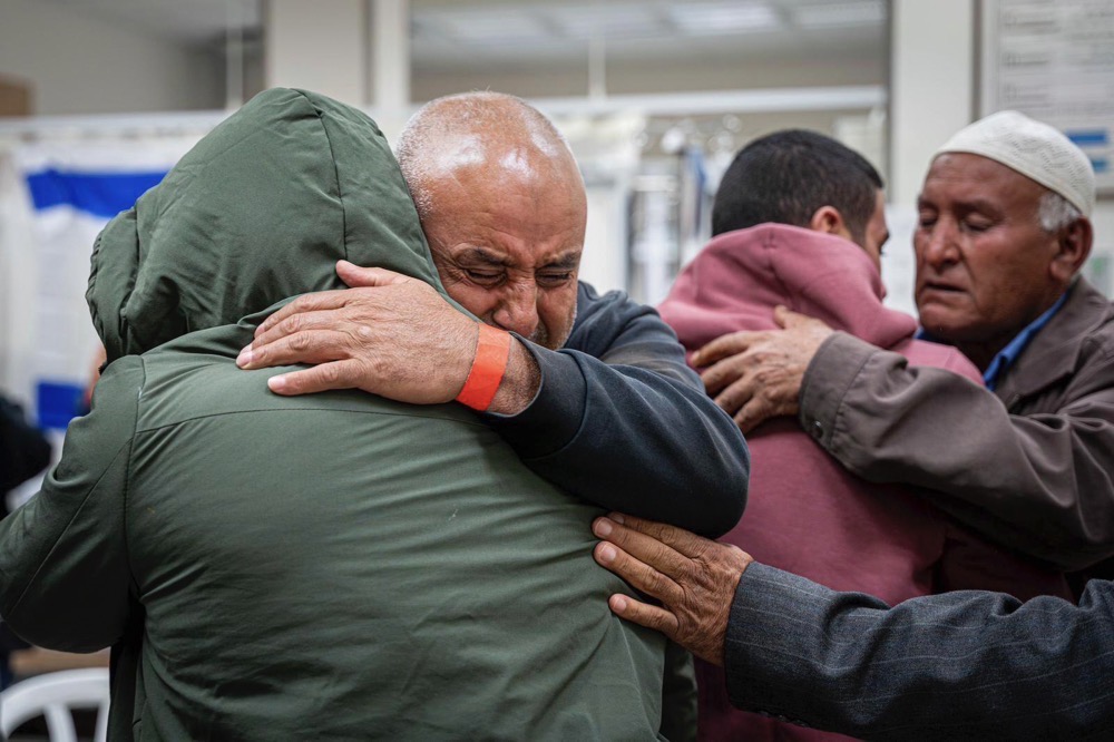 Photo of shows Israeli released hostages siblings Bilal, second right and Aisha Al-Ziyadne, left, reuniting with their family at Soroka Medical Center, Israel. (GPO/AP)
