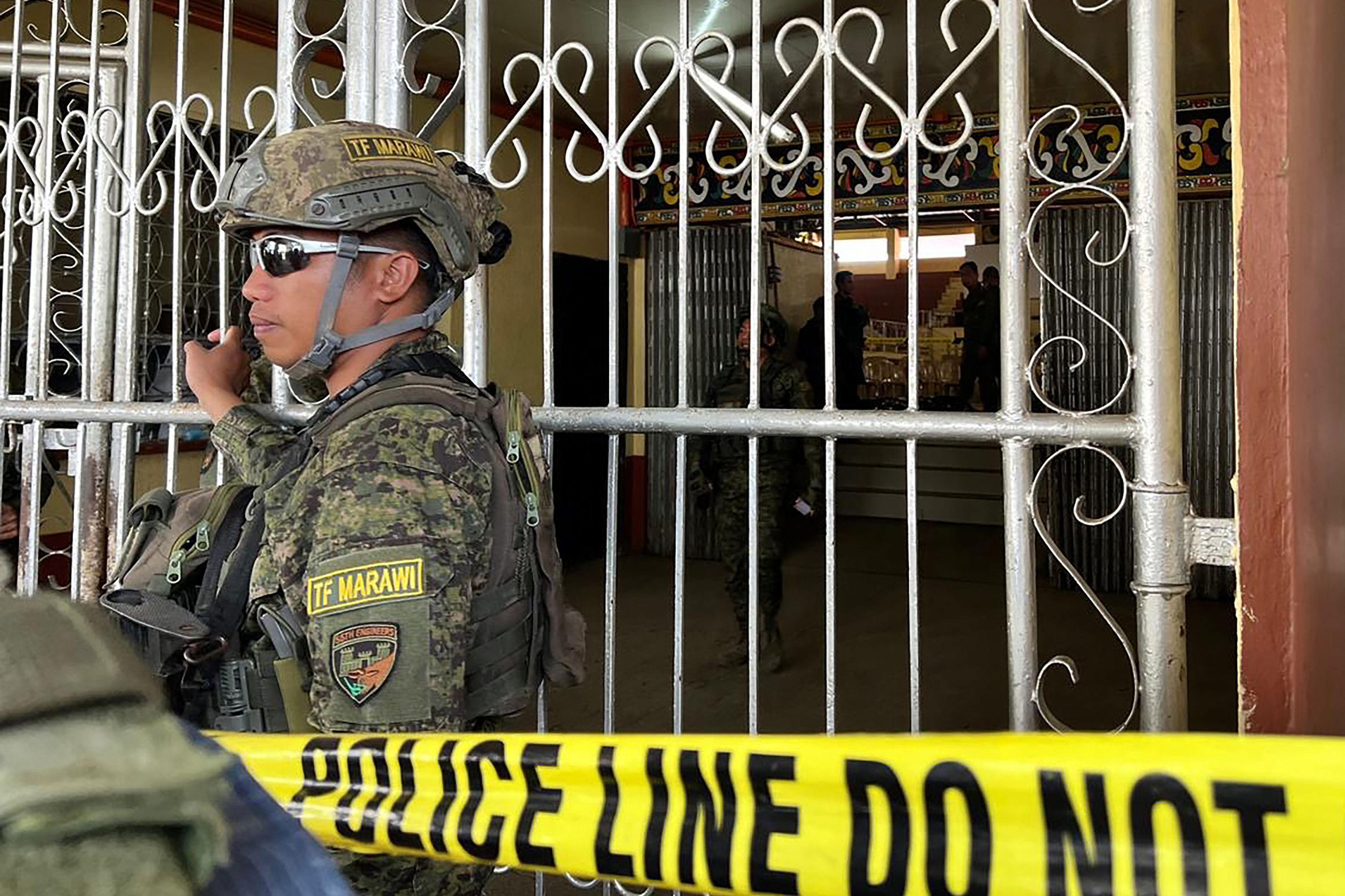 Military personnel stand guard at the entrance of a gymnasium while police investigators look for evidence after a bomb attack at Mindanao State University in Marawi, Lanao del sur province on Dec. 3, 2023. (AFP)