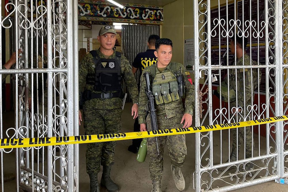 Military personnel stand guard at the entrance of a gymnasium while police investigators look for evidence after a bomb attack at Mindanao State University in Marawi on Dec. 3, 2023. (AFP)