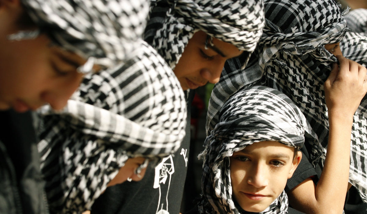 Palestinian youths wearing the traditional chequerred keffiyeh attend a rally held in the Palestinian refugee camp of Ain el-Helweh on the outskirts of the southern Lebanese city of Sidon on November 16, 2012, against Israel's military operation in the Gaza Strip. (AFP)