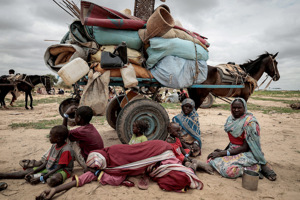 A Sudanese family who fled the conflict in Murnei in Sudan's Darfur region, sit beside their belongings while waiting to be registered by UNHCR. (Reuters)