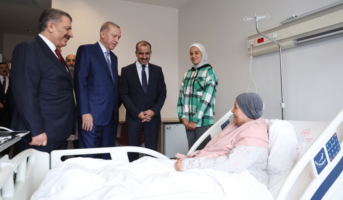 Turkish President Recep Tayyip Erdogan (R) and Turkish Health Minister Fahrettin Koca (L) speak with a Palestinian cancer patient, who had crossed from Gaza into Egypt and brought to Turkey for treatment, at Bilkent City Hospital in Ankara. (AFP)