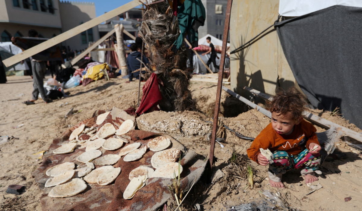 A child eats outside a tent, as displaced Palestinians, who fled their houses due to Israeli strike, shelter in a camp in Rafah, amid the ongoing conflict between Israel and Palestinian Islamist group Hamas, in the southern Gaza Strip, December 6, 2023. (REUTERS)