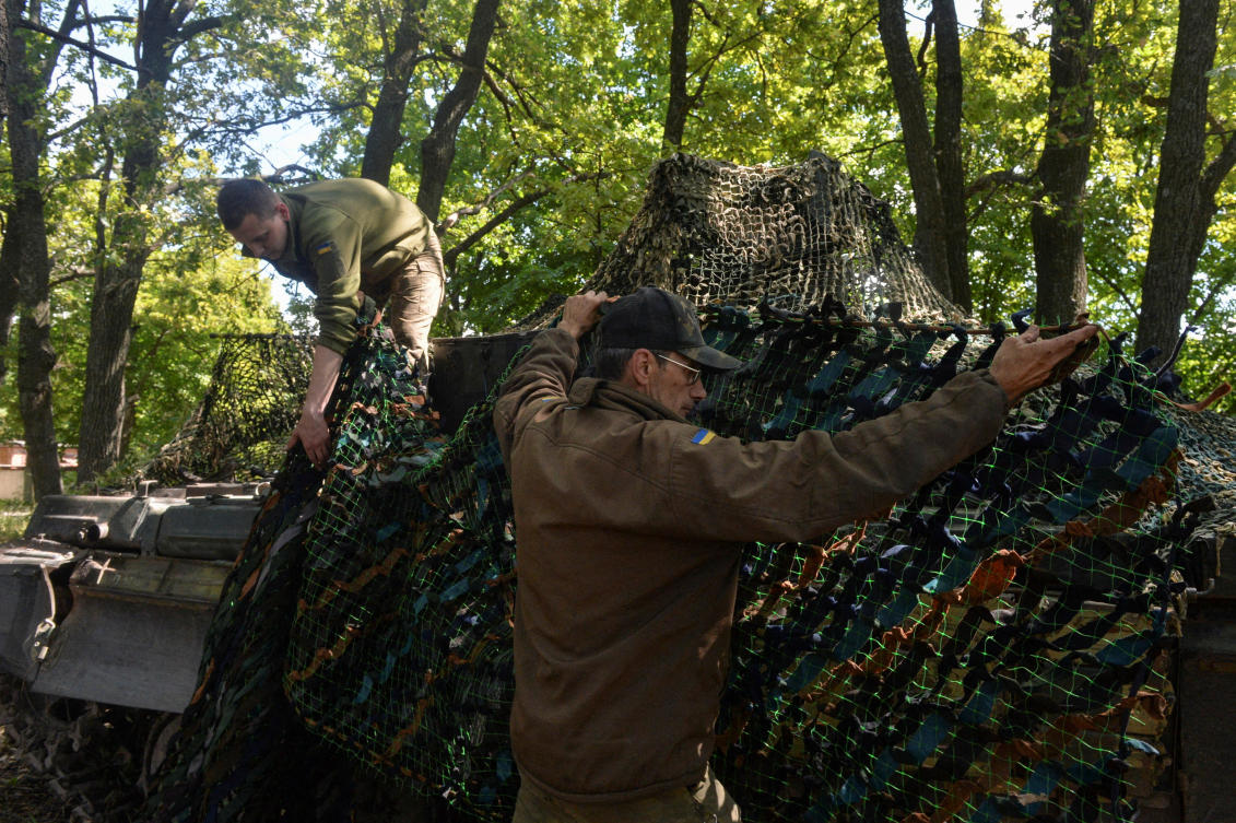 Ukrainian service members cover a tank with a camouflage net at their position, as Russia's attack on Ukraine continues, in Kharkiv. (File/Reuters)