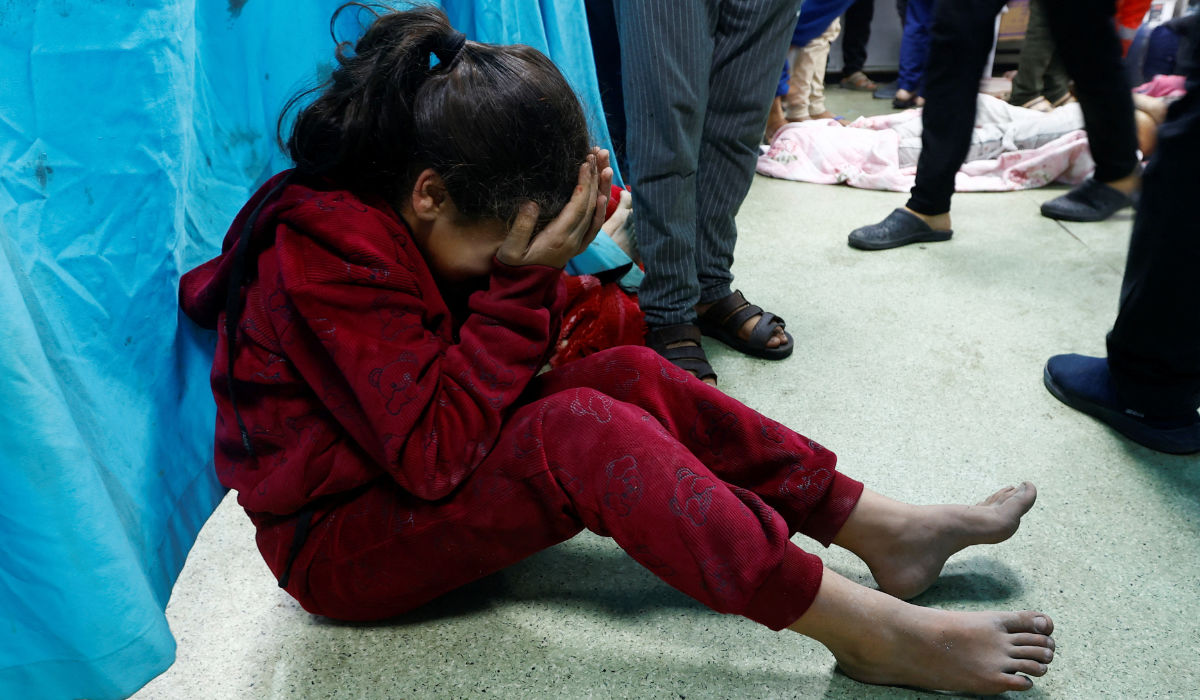 A wounded Palestinian child sits on the floor of Nasser hospital following Israeli strikes, amid the ongoing conflict between Israel and Palestinian Islamist group Hamas, in Khan Younis in the southern Gaza Strip, December 8, 2023. (REUTERS)