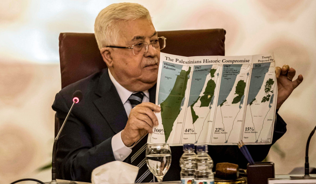 Palestinian president Mahmud Abbas holds a placard showing maps of (L to R) historical Palestine, the 1947 United Nations partition plan on Palestine, the 1948-1967 borders between the Palestinian territories and Israel, and a current map of the Palestinian territories without Israeli-annexed areas and settlements, as he attends an Arab League emergency meeting discussing the US-brokered proposal for a settlement of the Middle East conflict at the league headquarters in the Egyptian capital Cairo on February 1, 2020. (AFP)