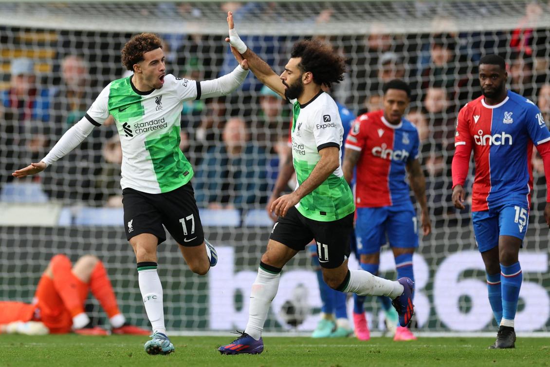 Liverpool’s Egyptian striker Mohamed Salah celebrates with Curtis Jones after scoring their first goal during their English Premier League match against Crystal Palace at Selhurst Park in south London on Dec. 9, 2023. (AFP)