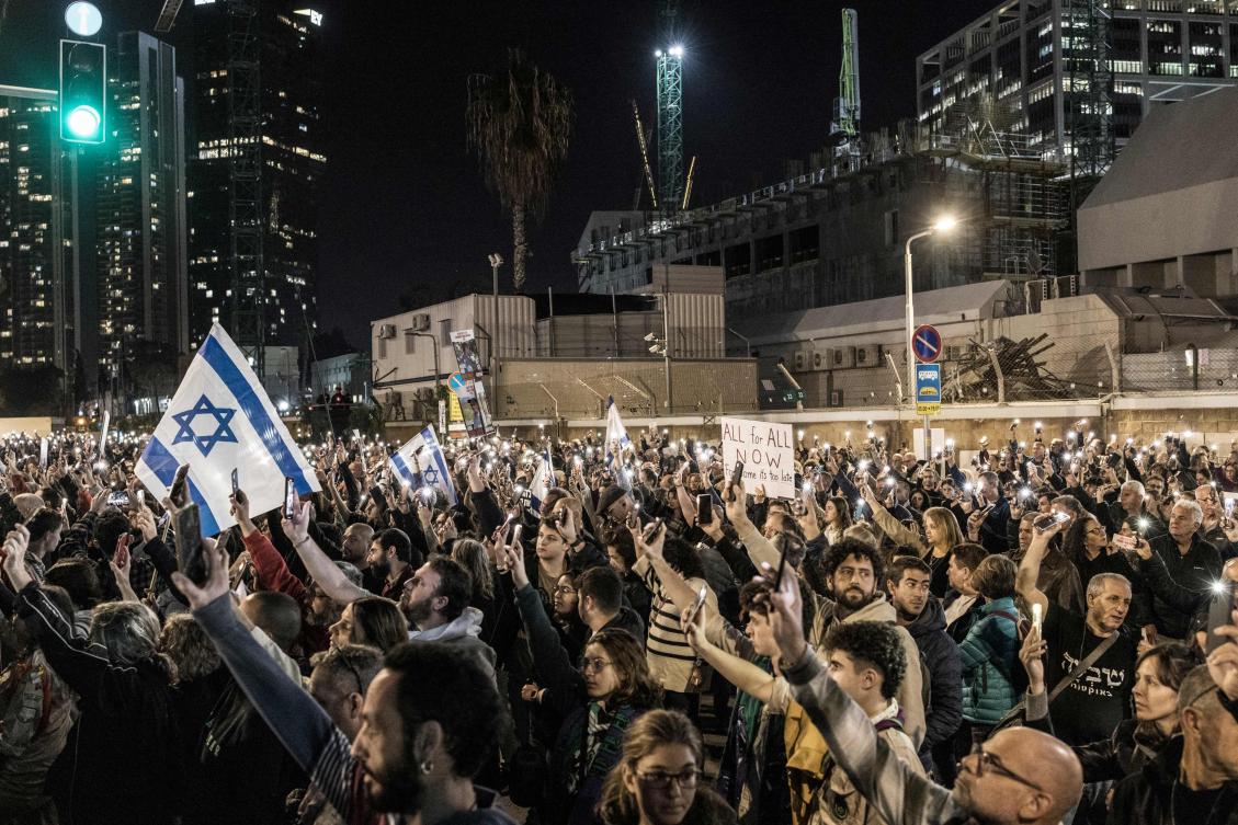 Demonstrators hold up their lit mobile phones as they gather during a demonstration calling for the release of hostages, outside the Tel Aviv Museum of Art, now informally called the “Hostages Square,” in Tel Aviv on Dec. 9, 2023. (AFP)