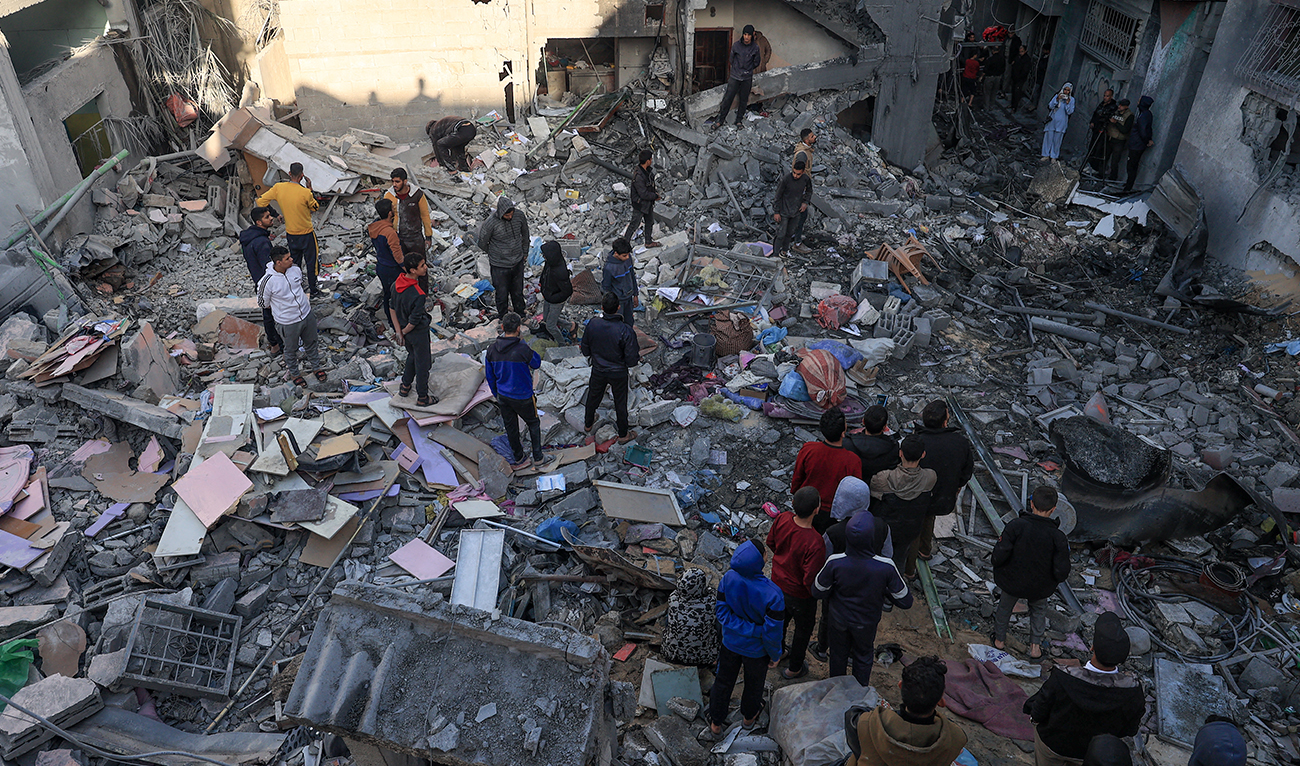 People gather amid the destruction following an early morning Israeli strike in Rafah in the southern Gaza Strip on December 9, 2023, amid continuing battles between Israel and the militant group Hamas. (AFP)