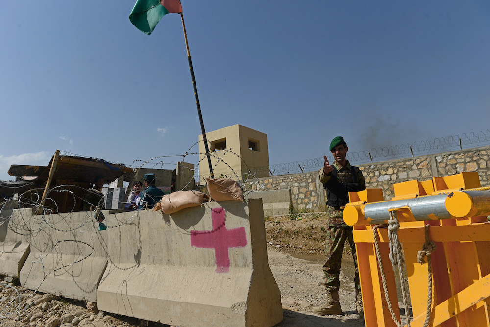 An Afghan soldier gestures outside the gates of a British-run military academy on the outskirts of Kabul on Aug 5, 2014. (AFP)