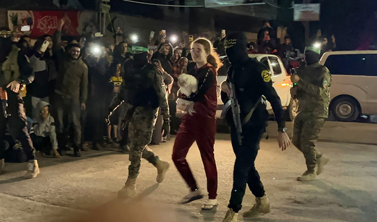 Hamas and Islamic Jihad fighters accompany a newly released Israeli hostage before handing her over to the Red Cross in Rafah, Gaza Strip, during a prisoner swap in Rafah,on November 28, 2023. (AFP/File)