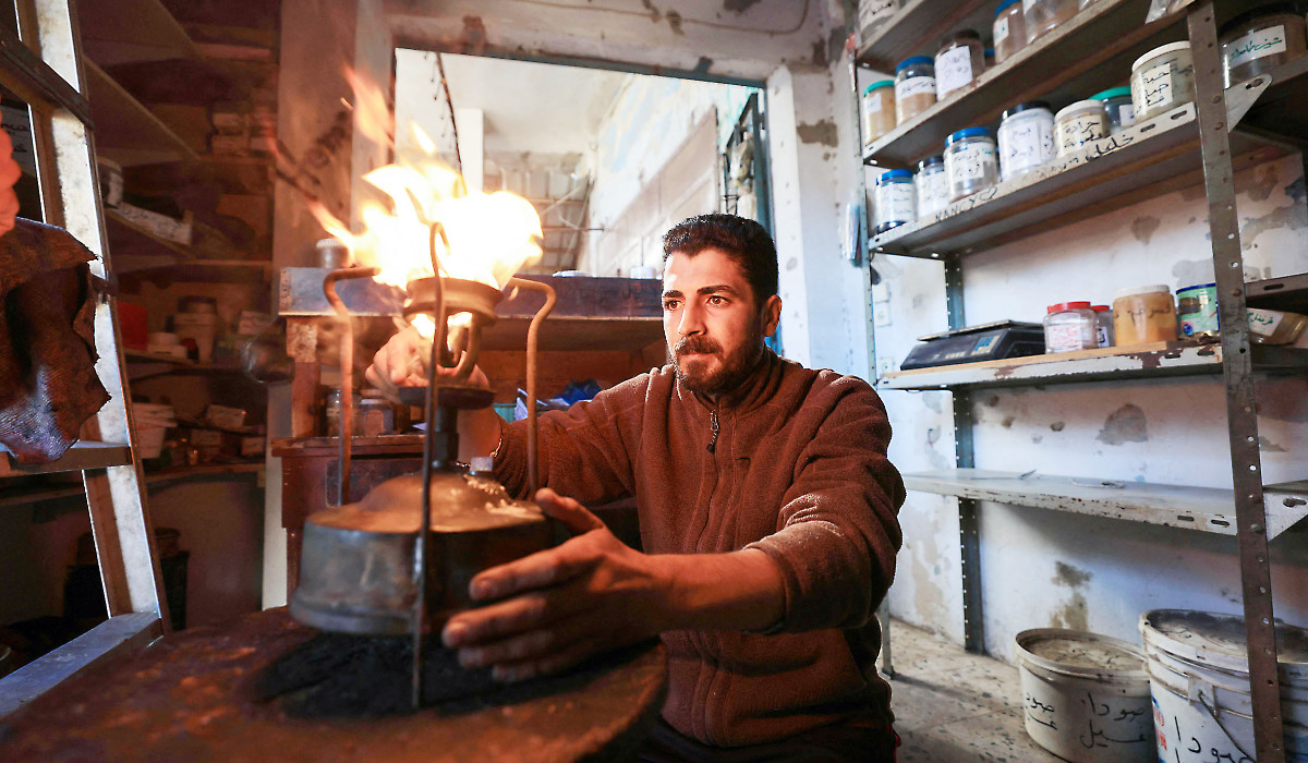 A shopkeeper lights a kerosene pressure stove in Rafah in the southern Gaza Strip, as Palestinians resort to the cheapest available alternatives for cooking and heating. (AFP)