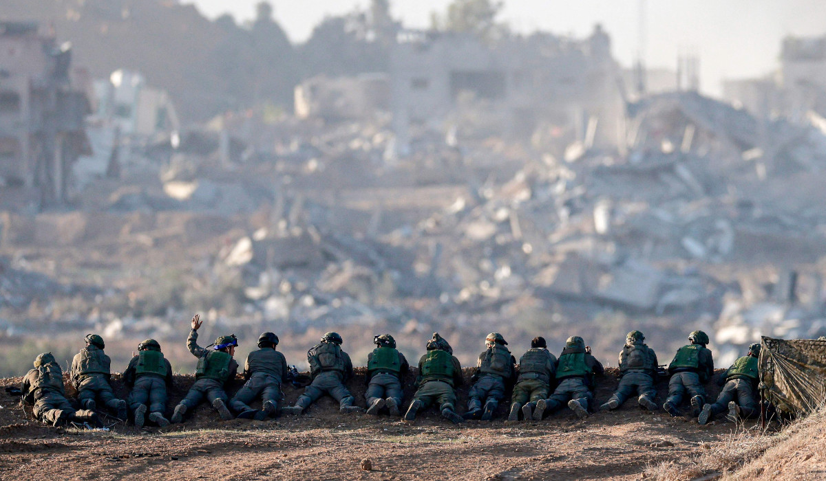 A picture taken in southern Israel near the border with the Gaza Strip on December 11, 2023, shows Israeli army soldiers keeping position on a hill overlooking northern Gaza, amid continuing battles between Israel and the militant group Hamas. (AFP)