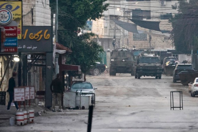 Israeli military vehicles arrive at the entrance of the Jenin refugee camp in the occupied West Bank during a reported raid on December 12, 2023. (AFP)