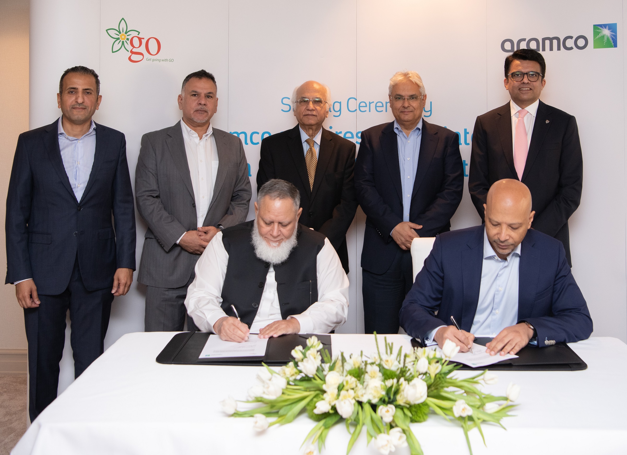 Aramco Executive Vice President of Products and Customers, Yasser Mufti, sitting right, signs the agreement with GO founder and CEO Khalid Riaz, sitting left. Supplied.