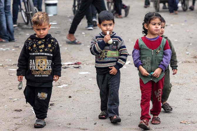 Children walk along a street in Rafah in the southern Gaza Strip on Dec. 12, 2023, amid continuing battles between Israel and Hamas. (AFP)