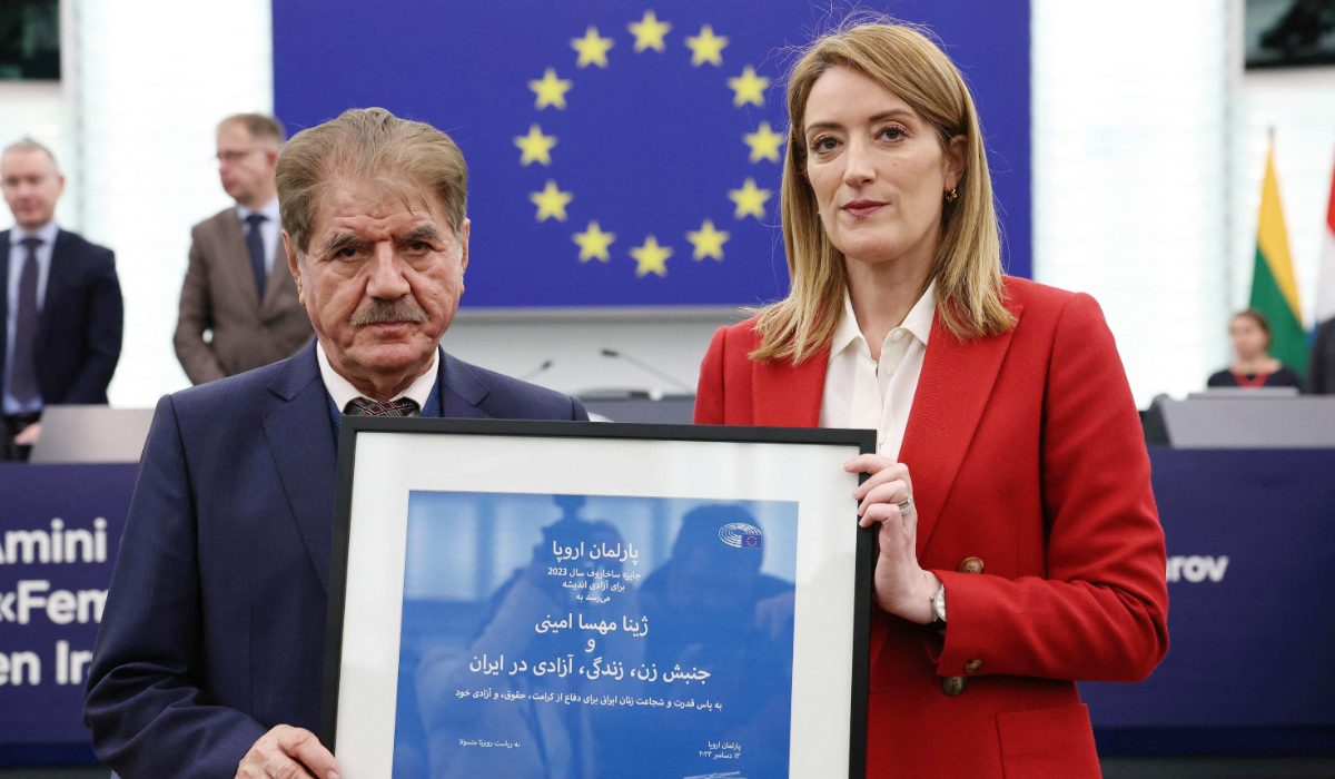 Mahsa Amini’s representative, Iranian lawyer Saleh Nikbakht, left, and European Parliament President Roberta Metsola with a plaque at the European Parliament in Strasbourg on Tuesday. (AFP)