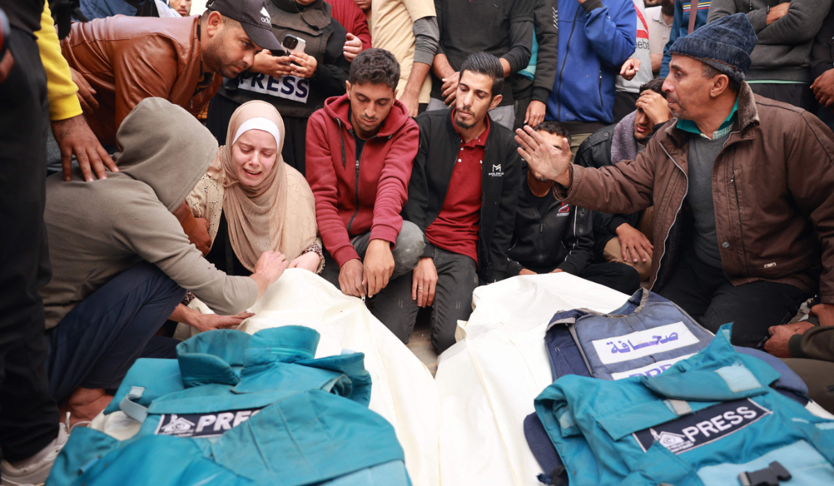 Relatives and colleagues of two Palestinian journalists Hasouna Slim and Sari Mansoor, killed in an Israeli strike, mourn over their bodies during their funeral in Deir al-Balah in the southern Gaza Strip on November 19, 2023. (AFP)