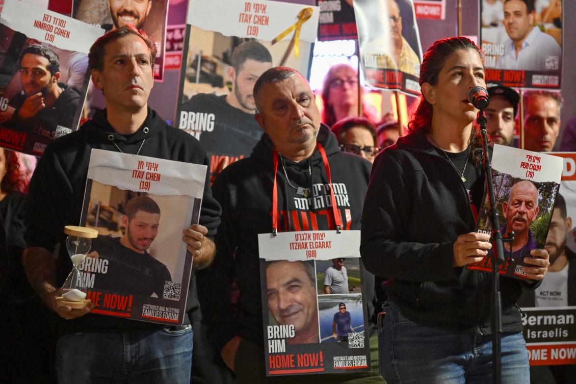 Relatives of Israeli hostages held in Gaza since the October 7 attack lift portraits as they deliver a statement to the media in Tel Aviv on Dec. 16, 2023. (AFP)