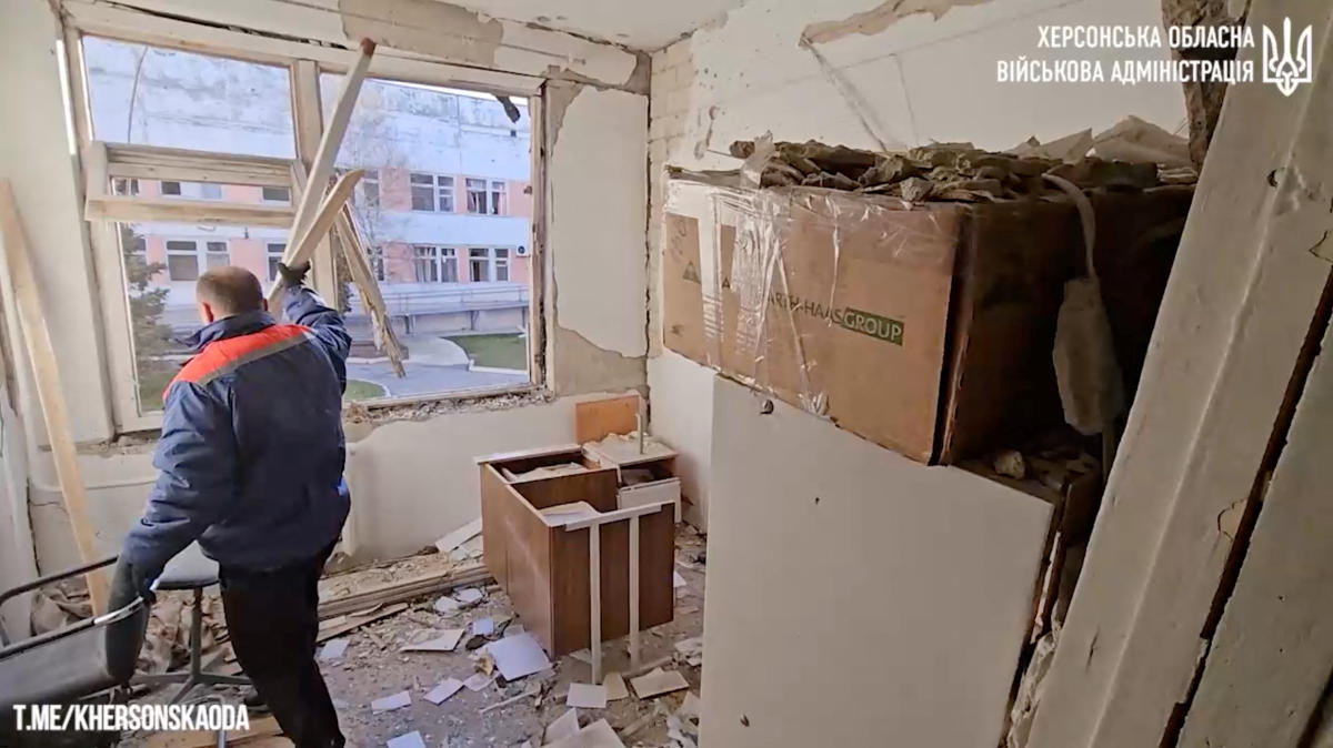 A man clears the damage in a room after Russian drones hit a hospital, in Stepanivka, Kherson Region in this screengrab taken from a video released on Dec. 16, 2023. (Reuters)