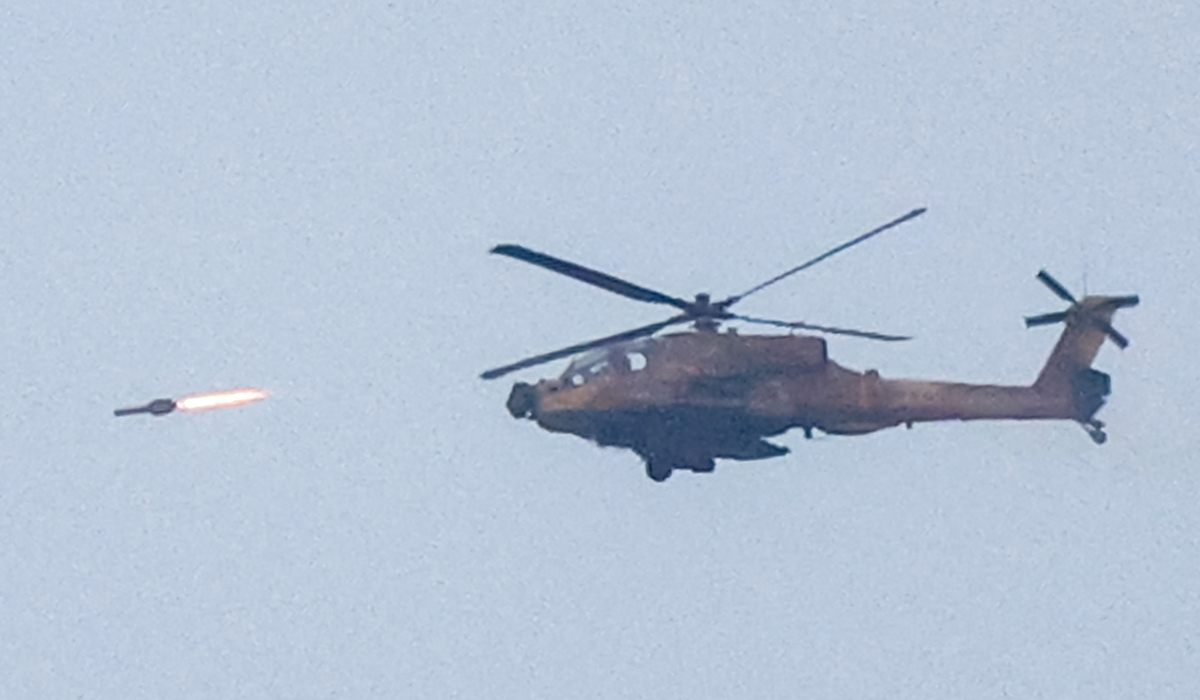 An Israeli air force attack helicopter fires a missile while flying over the northern Gaza Strip near the border with southern Israel on December 17, 2023 amid continuing battles between Israel and the militant group Hamas. (AFP)