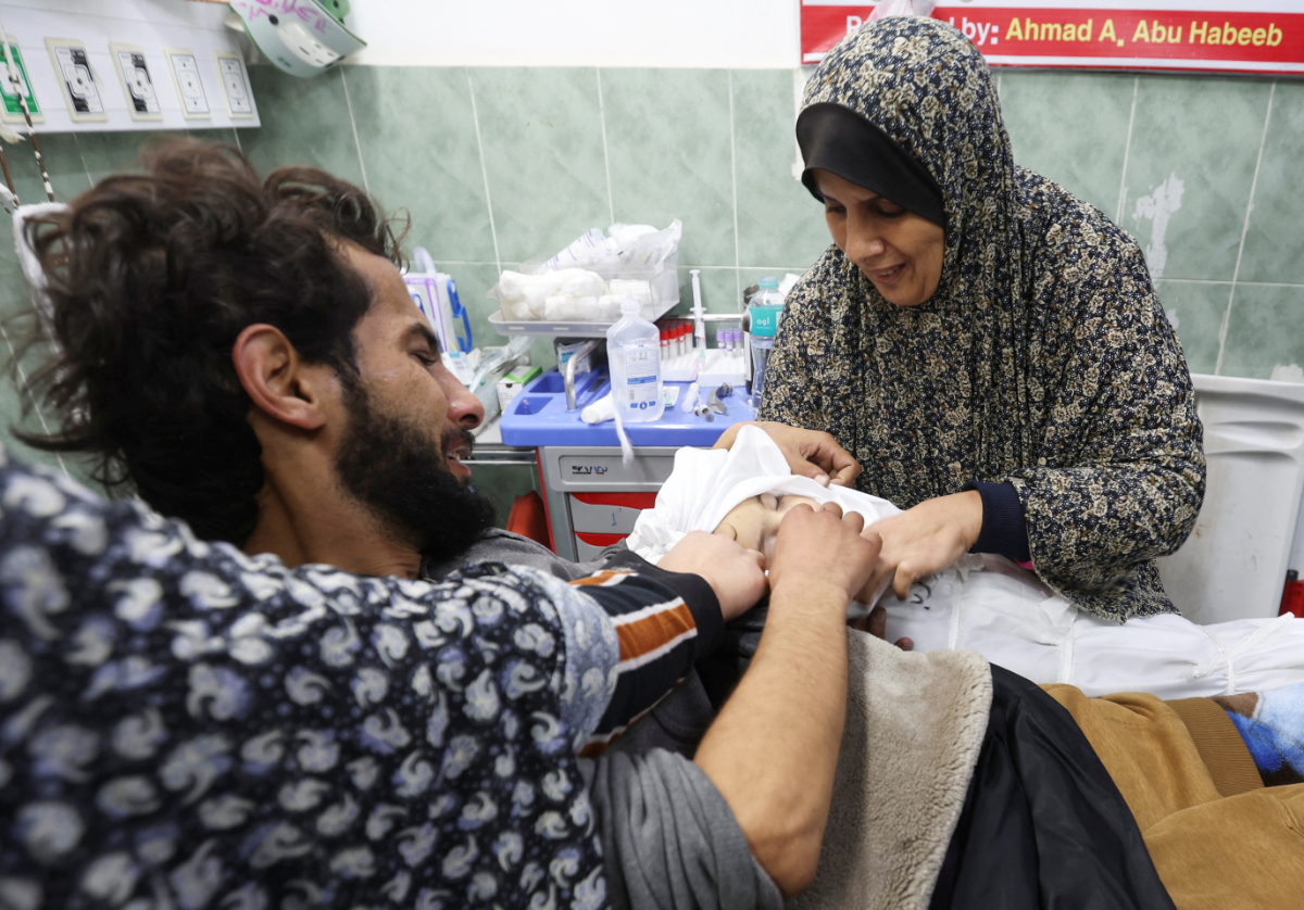 Suzan Zourob, the grandmother of two Palestinian children, a newborn Al-Amera Ayesha and a young boy Ahmed Zourob, who were killed in an Israeli strike, amid the ongoing conflict between Israel and the Palestinian Islamist group Hamas, mourns next to the children's wounded father, in Rafah, in the southern Gaza Strip, December 19, 2023. (REUTERS)