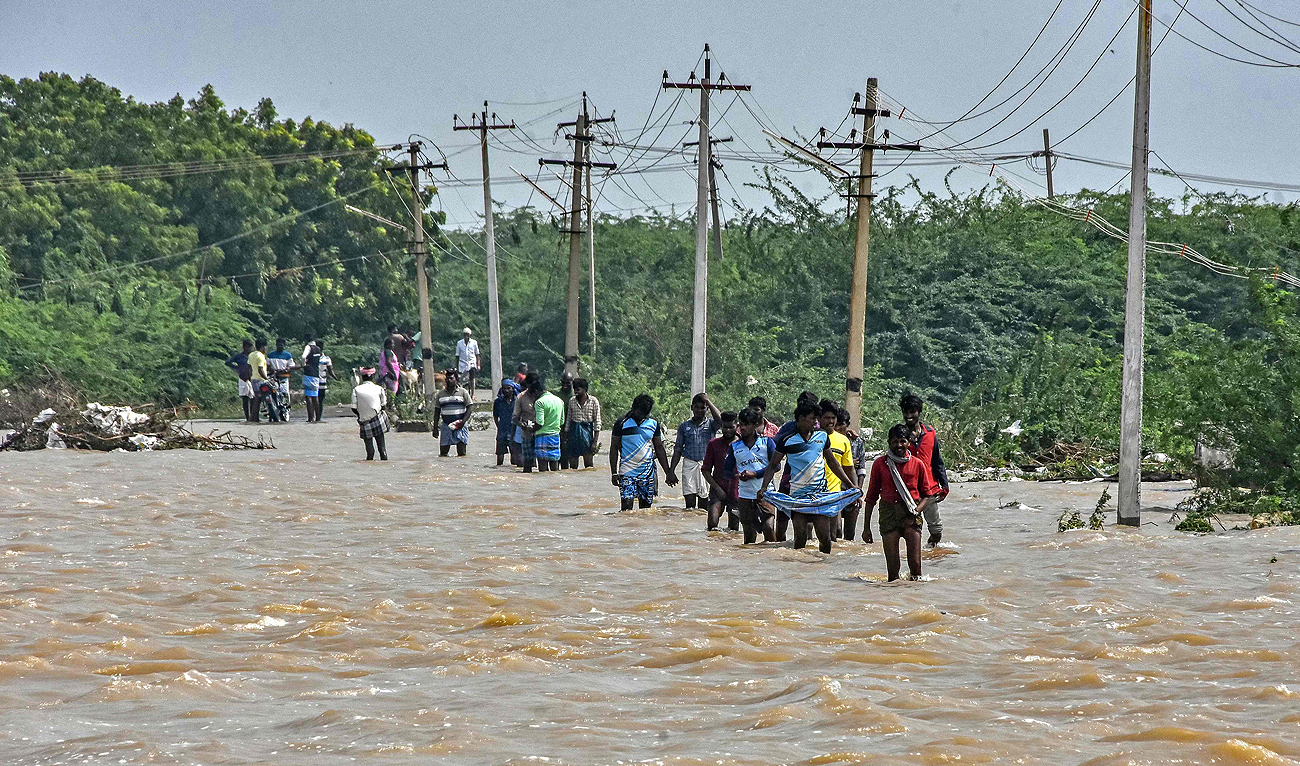 People wade through a flooded road after heavy rains in Thoothukudi on December 20, 2023. (AFP)