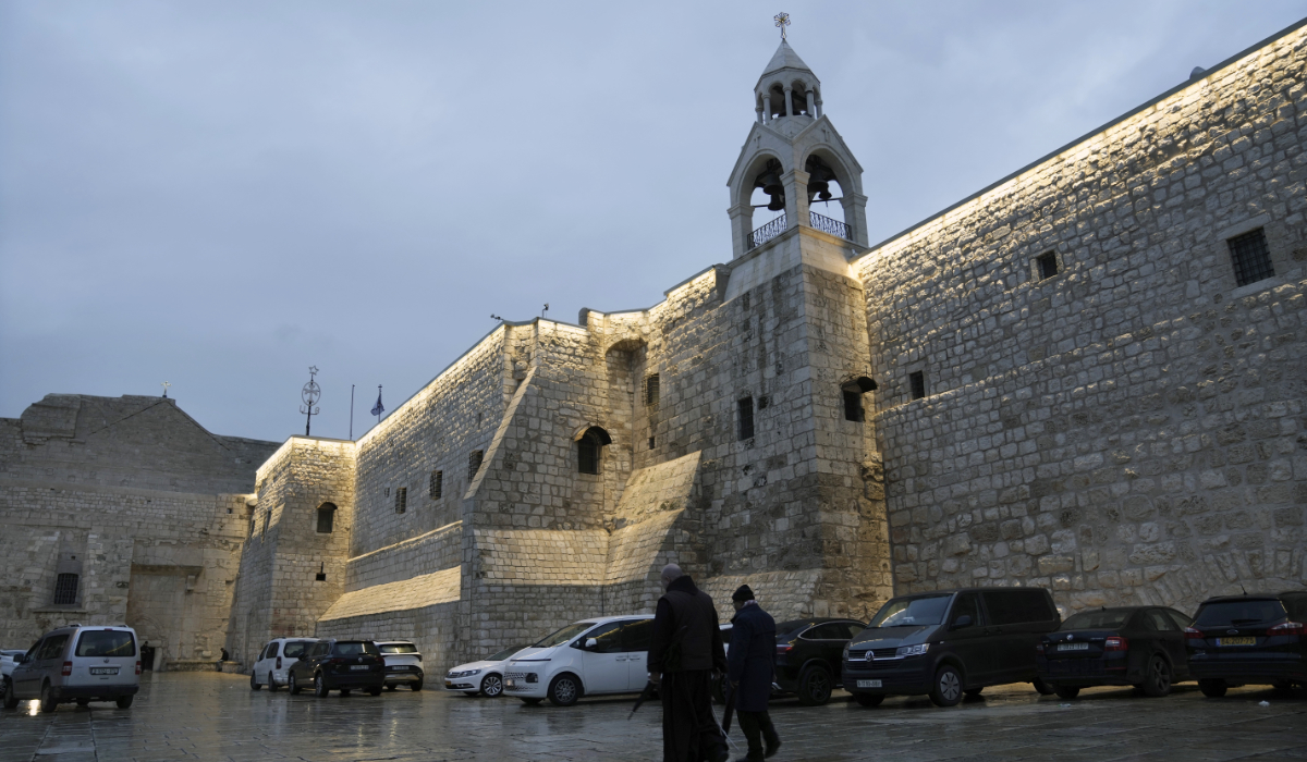 People walks by the Church of the Nativity, in the West Bank town of Bethlehem, Friday, Dec. 23, 2023. (AP)