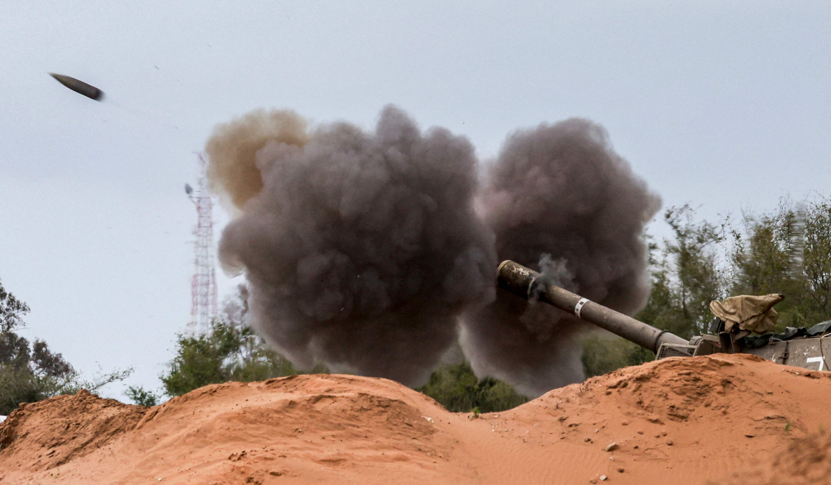 An Israeli army self-propelled artillery howitzer fires rounds from a position near the border with the Gaza Strip in southern Israel on December 24, 2023. (AFP)