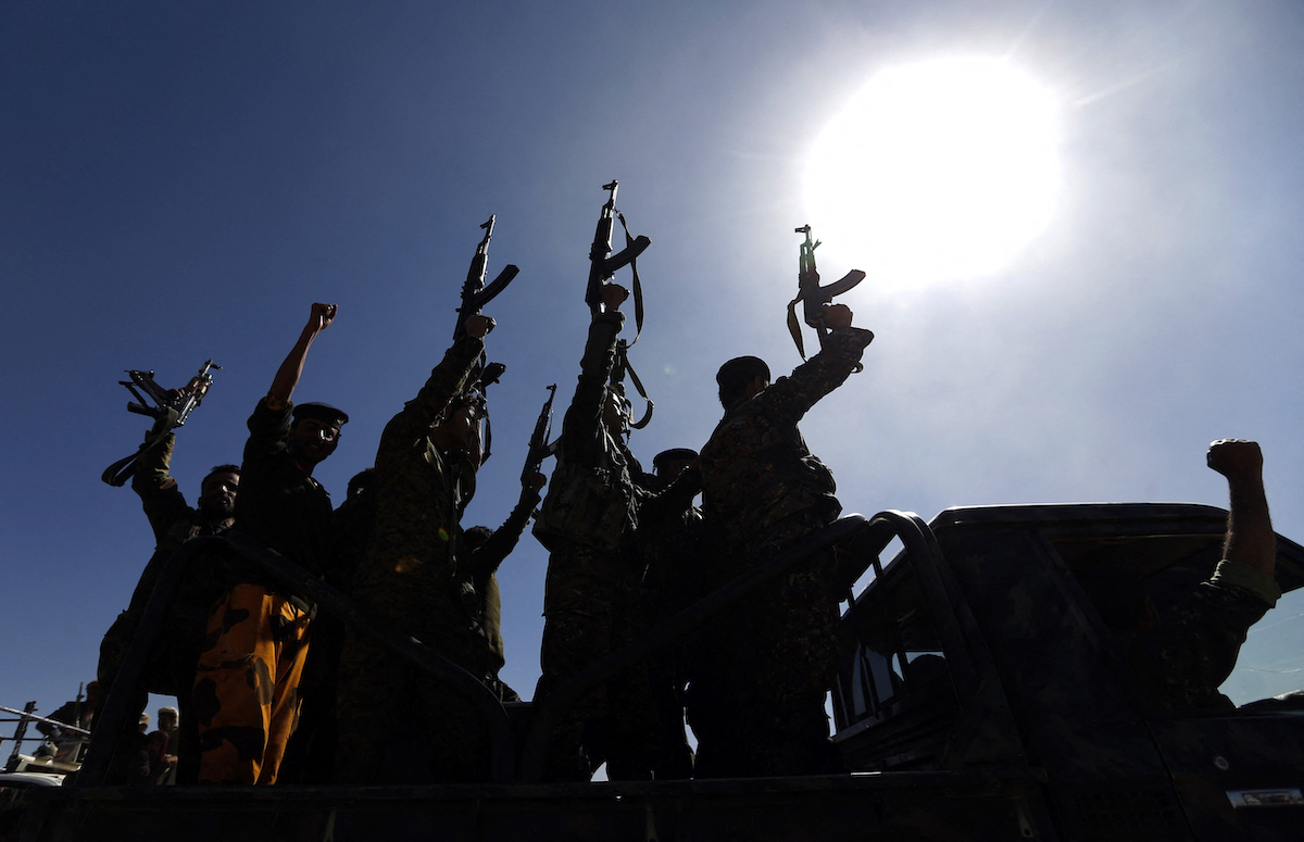 Newly recruited Houthi fighters chant slogans as they ride a military vehicle during a gathering in the capital Sanaa. (File/AFP)