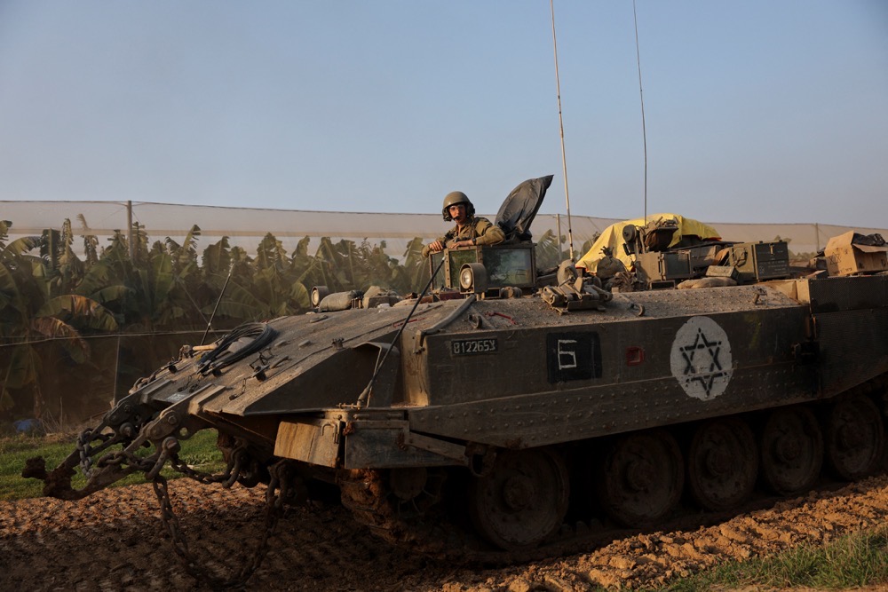 An Israeli soldier rides in an armoured personnel carrier (APC), amid the conflict between Israel and the Palestinian Islamist group Hamas, near the Israel-Gaza border, in southern Israel, December 25, 2023. (Reuters)