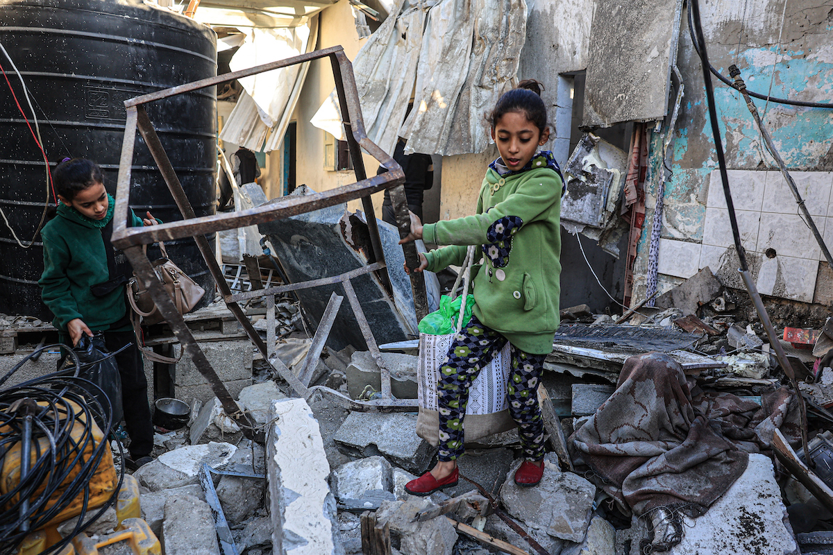 Palestinian girls search the rubble of a building following Israeli bombardment in Rafah in the southern Gaza Strip on December 26. (AFP)