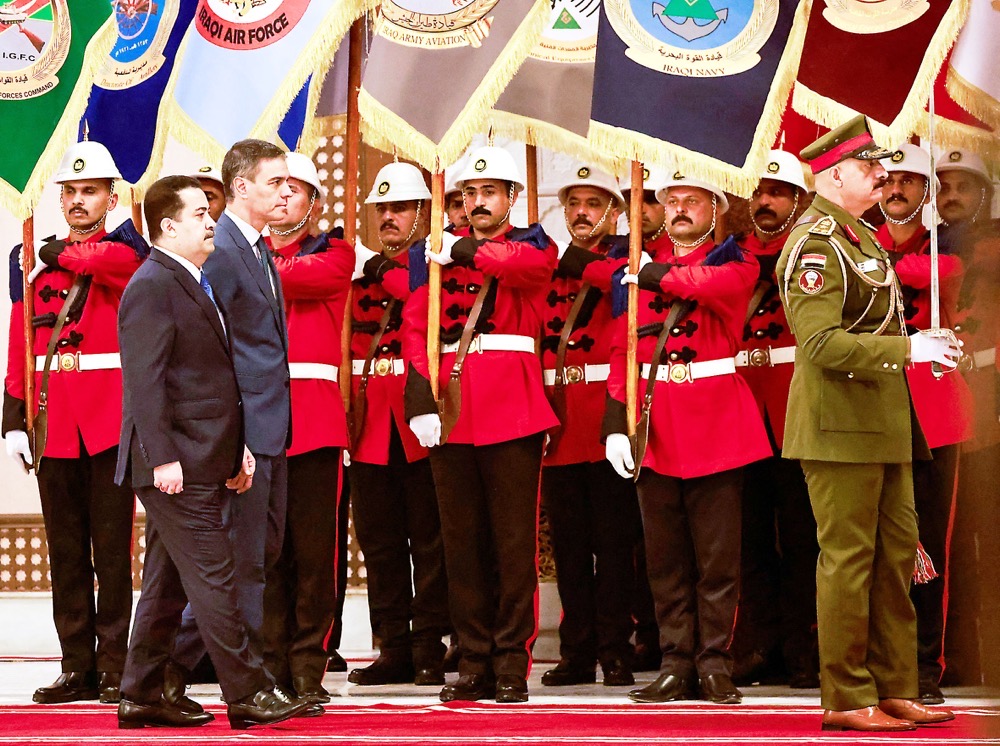 Iraqi PM Mohammed Shia Al-Sudani and Spanish PM Pedro Sanchez review troops in Baghdad on Thursday. (Reuters)