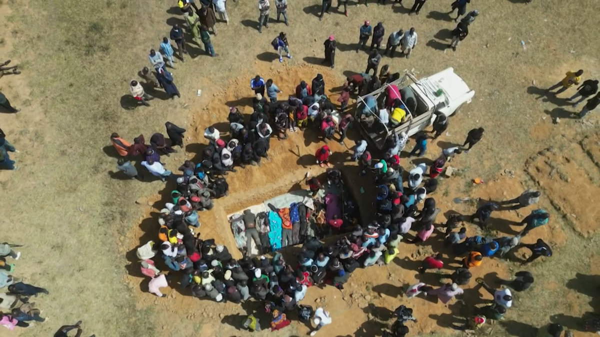 This image grab made from an AFPTV video taken on December 27, 2023 shows families burying in a mass grave their relatives killed in deadly attacks on Maiyanga village central Nigeria. (AFP)