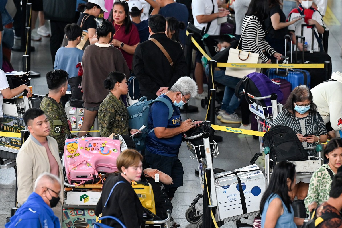 People queue at the check-in counters at Ninoy Aquino International Airport in Pasay, Metro Manila, the Philippines, on Dec. 22, 2023. (AFP/File)