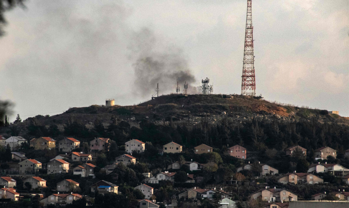 This picture taken on December 31, 2023 from southern Lebanon shows smoke billowing across the border in northern Israel in the vicinity of a military facility in Metula after the Lebanese Shiite movement Hezbollah launched a barrage of rockets amid ongoing cross-border tensions as fighting continues between Israel and Hamas militants in Gaza. (AFP)