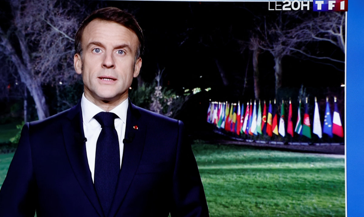 French President Emmanuel Macron is seen on a television screen as he delivers his New Year's speech to the nation at the Elysee Palace in Paris, France, December 31, 2023. (Reuters)