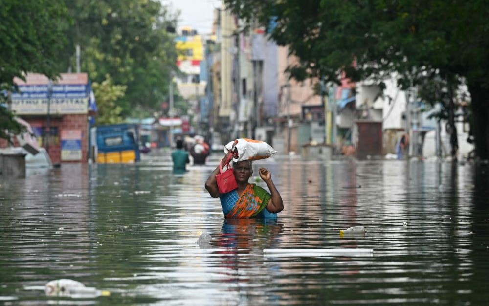 A woman, with her belongings, wades through a flooded street after heavy rain in Chennai, India, Dec. 6, 2023. (AFP)