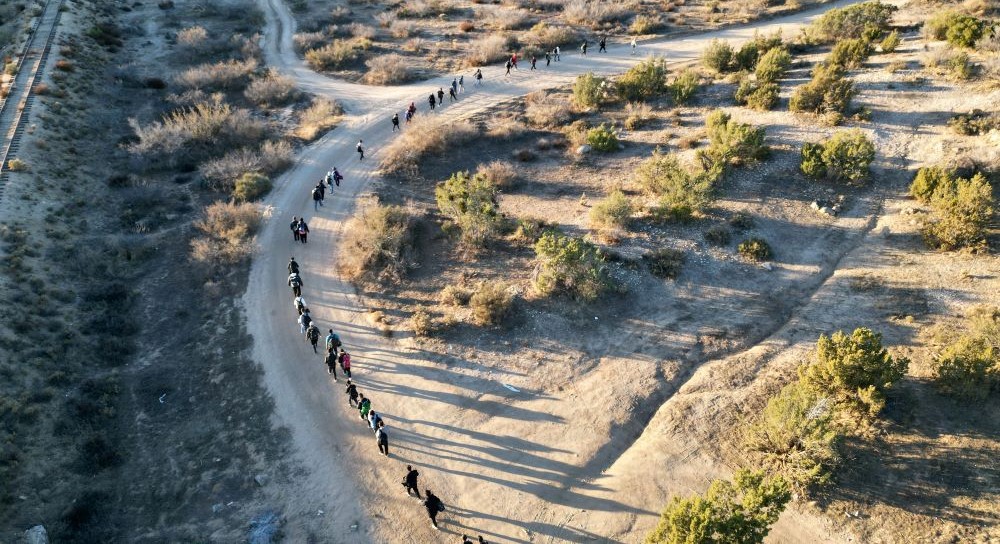 An aerial view shows border patrol agents leading migrants, who entered the US illegally, near Jacumba, California, Dec. 6, 2023. (AFP)