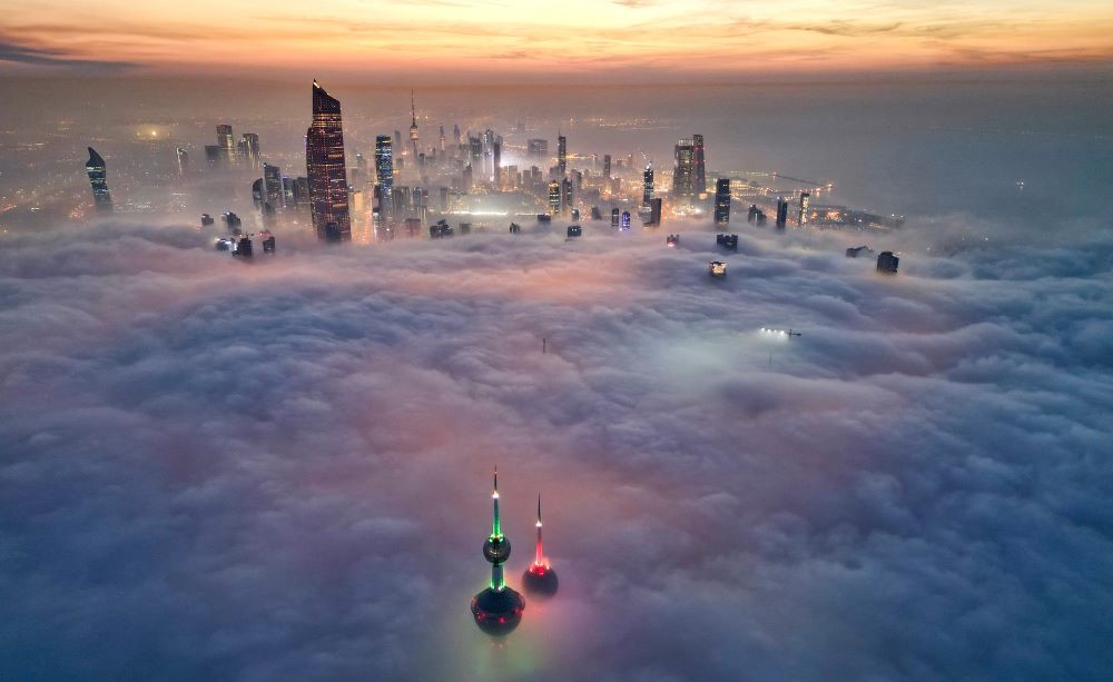 The landmark Kuwait Towers and other skyscrapers pierce through the cloud cover over Kuwait City, Dec. 10, 2023. (AFP)