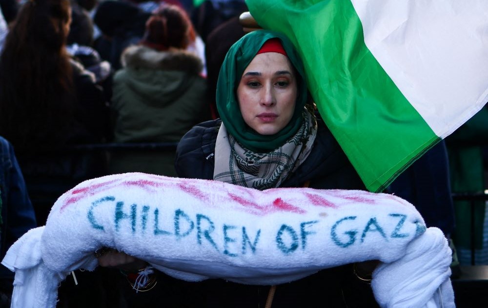 A protester holds a bundle reading Children of Gaza while attending a National March for Palestine in central London, Dec. 9, 2023. (AFP)