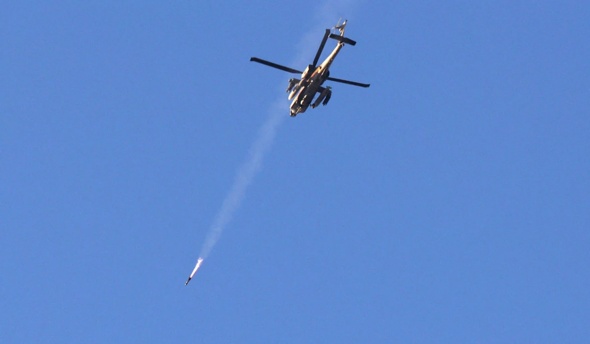 An Israeli air force attack helicopter fires a missile while flying over the border with the Gaza Strip near southern Israel on December 2, 2023, after battles resumed between Israel and Hamas militants. (AFP)