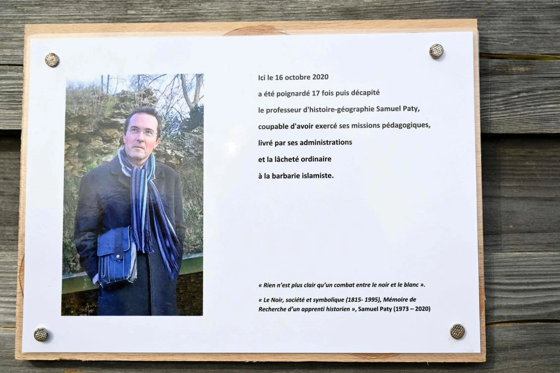 A photograph taken on Oct. 16, 2023 shows a commemorative plaque for slain teacher Samuel Paty (portrait) near the Bois d’Aulne school in Conflans-Sainte-Honorine, Paris. (AFP)