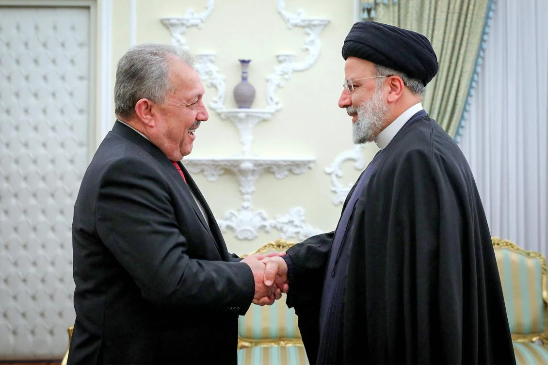 This handout picture provided by the Iranian presidency shows Iran’s President Ebrahim Raisi (R) receiving Syria’s Prime Minister Hussein Arnous in Tehran on December 9, (AFP/Handout/Iranian Presidency)