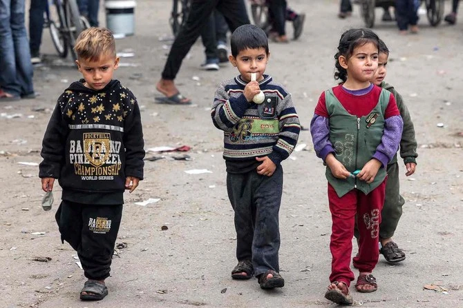 Children walk along a street in Rafah in the southern Gaza Strip on Dec. 12, 2023, amid continuing battles between Israel and Hamas. (AFP)