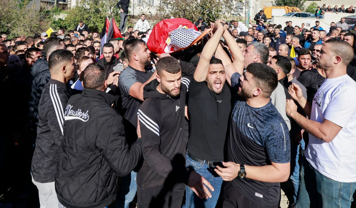 Mourners carry the body of Palestinian youth Atallah Badah, 16, during his funeral at his village of Deir Amar east of Ramallah in the Israeli-occupied West Bank on Saturday. (AFP)