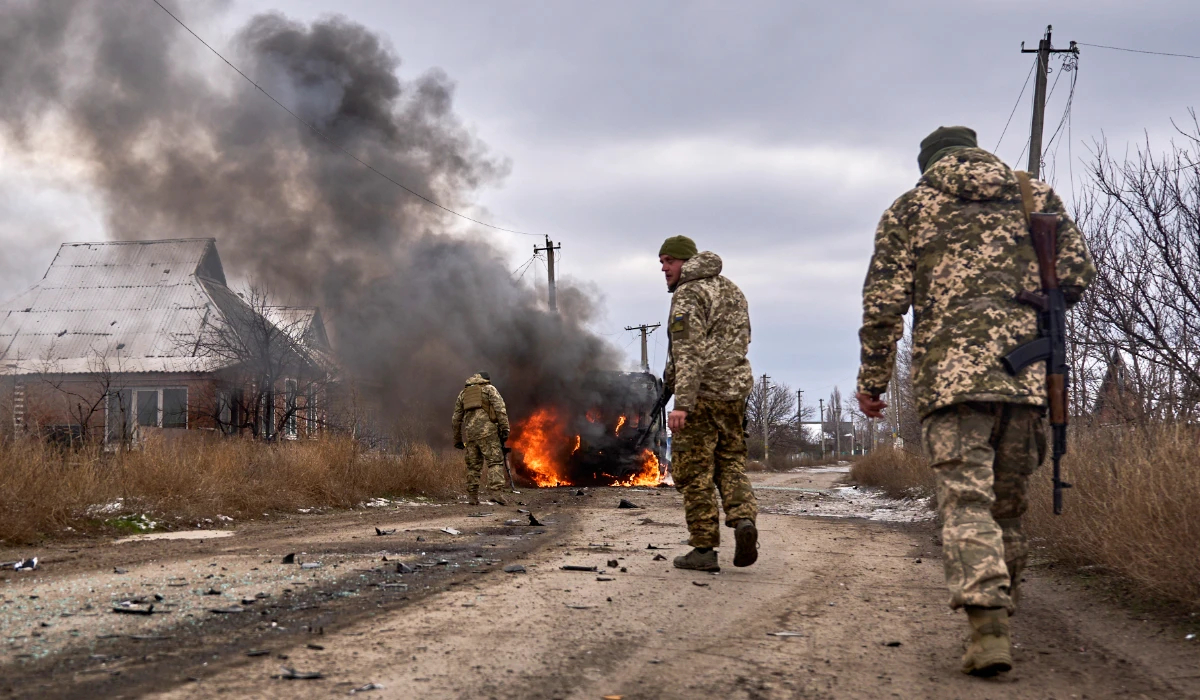 In this photo provided by the Ukrainian 10th Mountain Assault Brigade "Edelweiss", Ukrainian soldiers pass by a volunteer bus burning after a Russian drone hit it near Bakhmut, Donetsk region, Ukraine, Thursday, Nov. 23, 2023. (AP)
