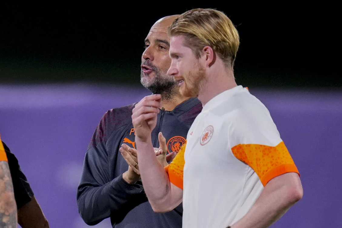 Manchester City’s head coach Pep Guardiola talks next to Kevin de Bruyne during a training session at the King Abdullah Sports City Stadium in Jeddah on Dec. 18, 2023. (AP)